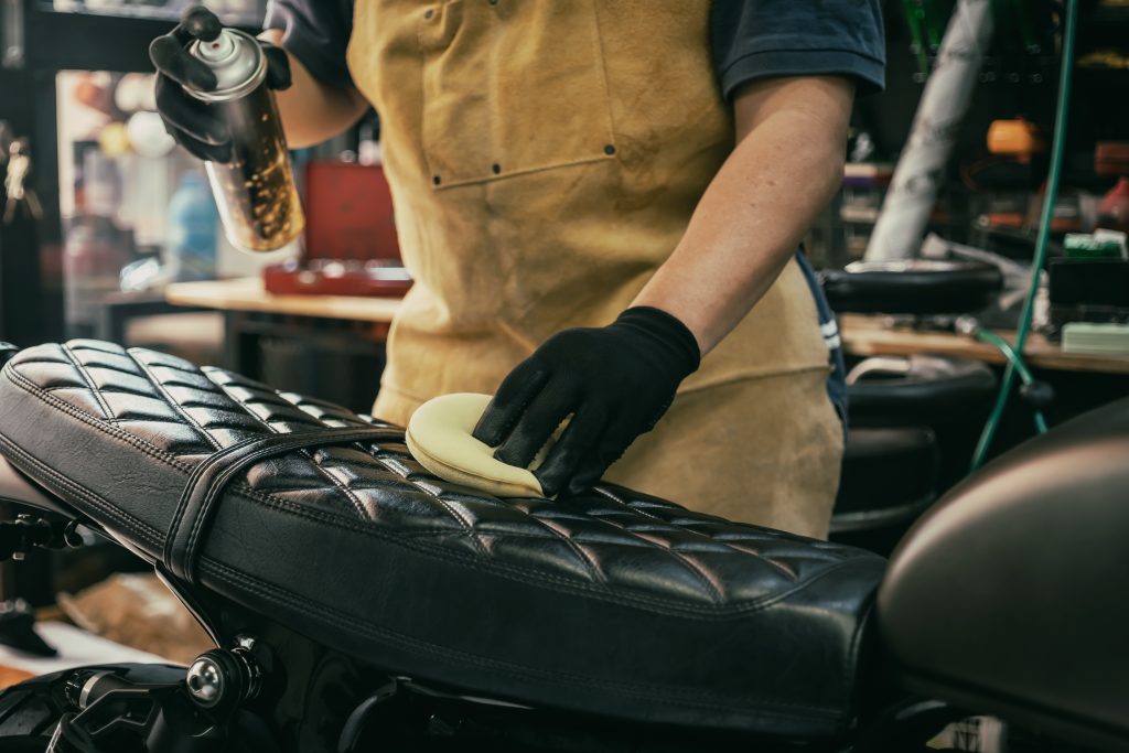 Leather motorcycle seat being treated