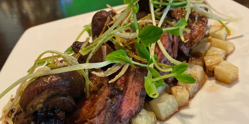 Grilled 8oz Beef Tenderloin with buttered potatoes, leek crisps, and crimini mushrooms