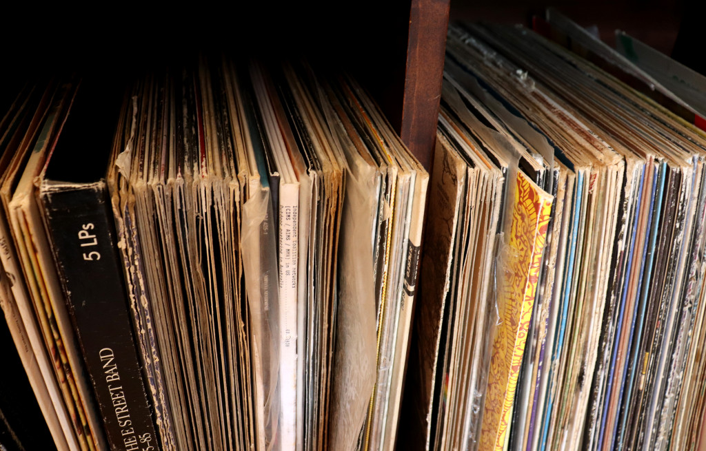 Vinyl records upright on a storage shelf