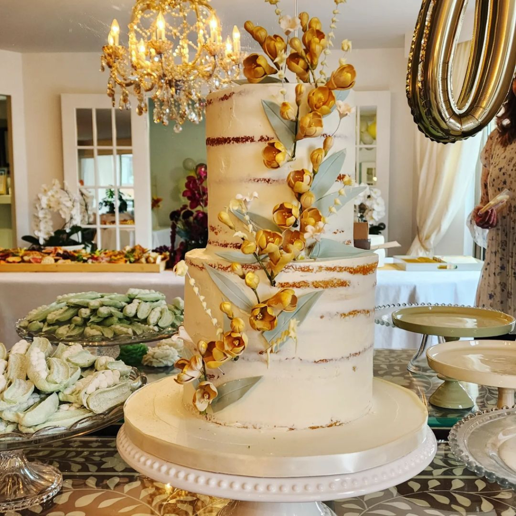 Large cake with flowers and an assortment of cookies