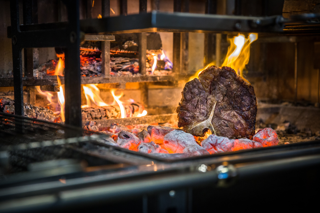 Steak cooking in an open grill